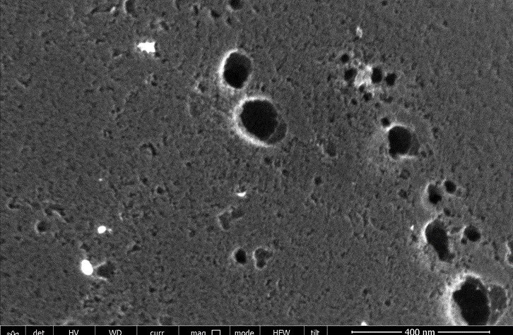 Scanning electron micrograph of bare activated carbon cloth at 400 nanometre scale, showing the pore mouths in the fibre surface