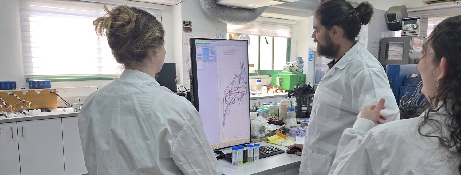 The SelectREE team reviewing cyclic voltammetry results together in the laboratory